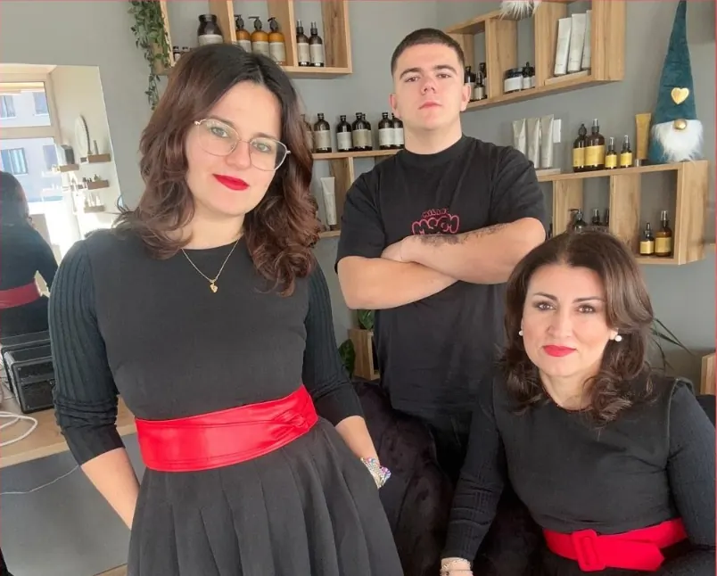 Il team di Joana Parrucchieri nel salone, davanti agli scaffali dei prodotti.